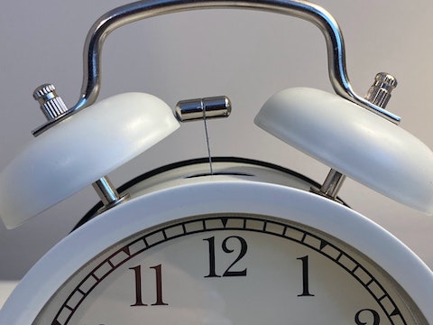 a white analog alarm clock